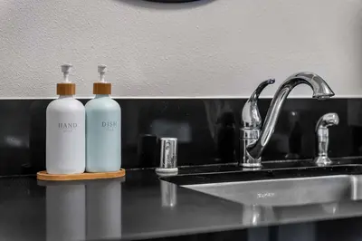 two bottles ofodorizers sitting on a counter next to a sink at Stylish in Sunny Santa Monica walk to Beach & Pier in Los Angeles