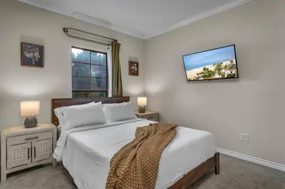 a bedroom with a bed and a tv on the wall at Stylish in Sunny Santa Monica walk to Beach & Pier in Los Angeles