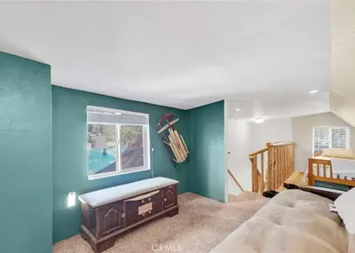 a bedroom with a green wall with a bed and a window at Merri Bear in Big Bear Lake