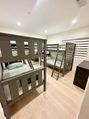 a room with two bunk beds and a bench at Qazaq Hostel in Los Angeles