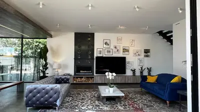 a living room with blue couches and a tv at Luxurious Venice Oasis Home in Los Angeles