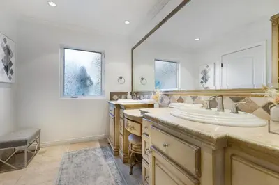 a bathroom with two sinks and two mirrors at Erwin Estate in Los Angeles