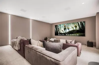 a living room with a large couch and a tv at Swallow Sanctuary in Los Angeles