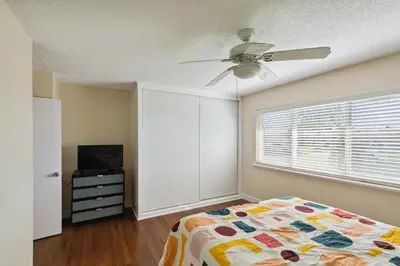 a bedroom with a bed and a ceiling fan at Modern Relaxing Retreat with Private Pool home in Azusa