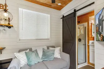 a living room with a couch and a window at Tiny Farmhouse on Wheels in Santa Clarita