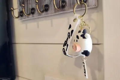 a keychain of a cow hanging on a wall at Tiny Farmhouse on Wheels in Santa Clarita