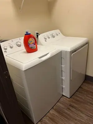a detergent bottle sitting on top of a washing machine at Luxury Modern Condo 3-min from Six Flags w/PS5, 1GB Fast Wi-fi Kingbed in Santa Clarita