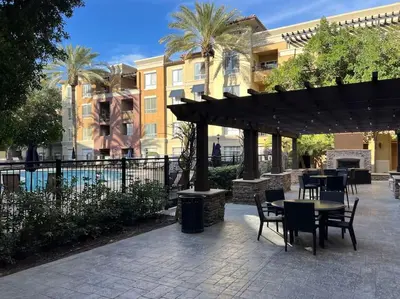 a patio with tables and chairs under an umbrella at Luxury Modern Condo 3-min from Six Flags w/PS5, 1GB Fast Wi-fi Kingbed in Santa Clarita