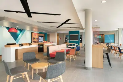 a lobby with chairs and tables and a cafeteria at avid hotel Victorville Hesperia by IHG in Victorville