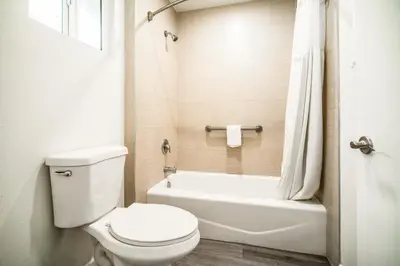 a bathroom with a toilet and a tub and a sink at Bell Manor Motel in Bell