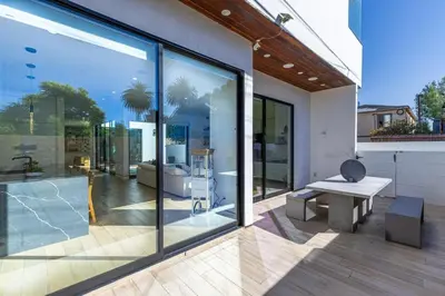a patio with a bench and large glass windows at The Penmar Retreat - Luxurious resort-style oasis in Los Angeles
