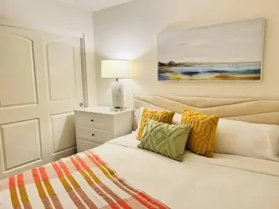 a bedroom with a white bed with yellow and green pillows at Up to 25% OFF / New Built for Ideal Extended Stay in Fontana