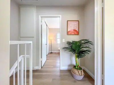 a hallway with a potted plant and a staircase at Sweet 2 bd for monthly stay! 20 mi to Disney in Diamond Bar