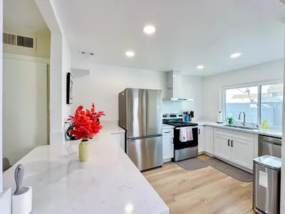 a kitchen with a white counter and a stainless steel refrigerator at Sweet 2 bd for monthly stay! 20 mi to Disney in Diamond Bar