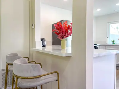 a kitchen with two chairs and a counter with a vase of flowers at Sweet 2 bd for monthly stay! 20 mi to Disney in Diamond Bar