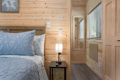 a bedroom with a bed and a lamp on a table at Brandnew cabin in Kernville