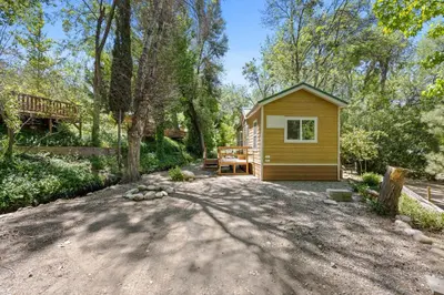 a small cabin in the woods with a patio at Brandnew cabin in Kernville