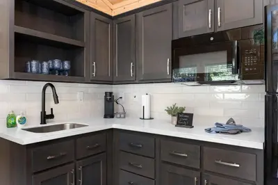 a kitchen with brown cabinets and a sink at Brandnew cabin in Kernville