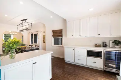 a kitchen with white cabinets and a vase of flowers at Beautiful Large 3 Bedroom 2 Bath Plus Pool and Jacuzzi in Los Angeles