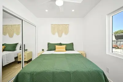 a bedroom with a bed with a green comforter at Sunset Beach Retreat next to Water Tower and Ocean in Sunset Beach