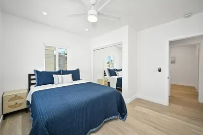 a bedroom with a blue bed with a ceiling fan at Sunset Beach Retreat next to Water Tower and Ocean in Sunset Beach