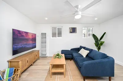 a living room with a blue couch and a tv at Sunset Beach Retreat next to Water Tower and Ocean in Sunset Beach