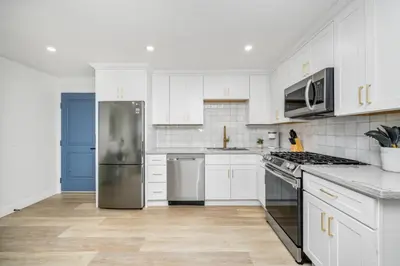a kitchen with white cabinets and a stainless steel refrigerator at 130 Anderson St A in Sunset Beach