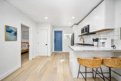 a kitchen with white cabinets and a blue door at 130 Anderson St B in Sunset Beach