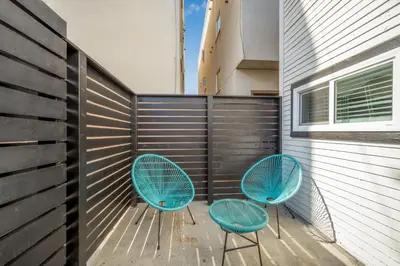 two blue chairs on a patio with a wall at 130 Anderson St B in Sunset Beach