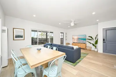 a living room with a table and a couch at Brand New Home by the Beach & Historic Sunset Water Tower in Sunset Beach