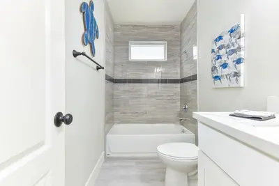 a white bathroom with a tub and a toilet at Sunset Island 3 Level Home on the Water sleeps 10 in Sunset Beach