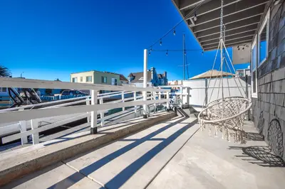 a couple of chairs sitting on a balcony at Sunset Island 3 Level Home on the Water sleeps 10 in Sunset Beach