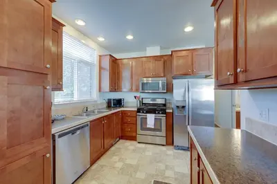 a kitchen with wooden cabinets and stainless steel appliances at Cozy Oak View Getaway about 5 Mi to Ojai Valley! in Oak View