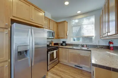 a kitchen with a stainless steel refrigerator and wooden cabinets at Charming Oak View Retreat about 5 Mi to Ojai Valley! in Oak View
