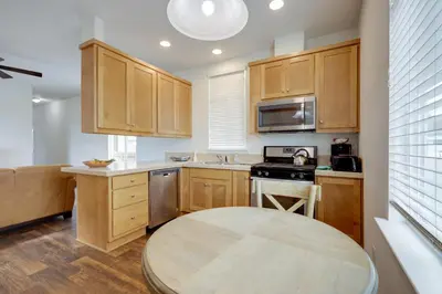 a kitchen with wooden cabinets and a round table at Oak View Vacation Rental about 3 Mi to Lake Casitas! in Oak View