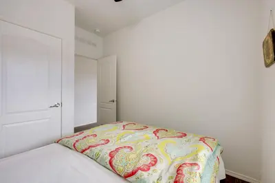 a white bedroom with a bed with a colorful blanket at Oak View Vacation Rental about 3 Mi to Lake Casitas! in Oak View