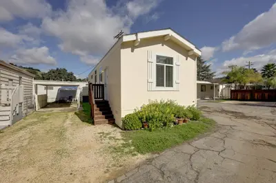 a small white house with a driveway at Oak View Home with Private Covered Patio! in Oak View