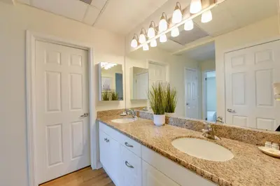 a bathroom with two sinks and a large mirror at Sunny Condo with Panoramic Ocean Views in Los Angeles