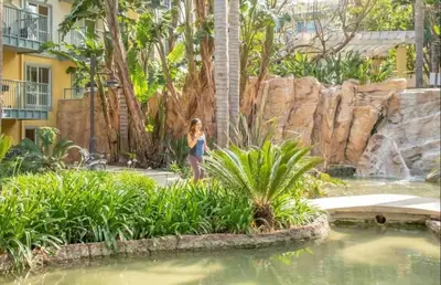 a woman standing in front of a fountain in a garden at Sunny Condo with Panoramic Ocean Views in Los Angeles