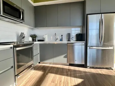 a kitchen with a stainless steel refrigerator and cabinets at Large Hollywood Corner 2 Bedroom with Private Balcony in Los Angeles