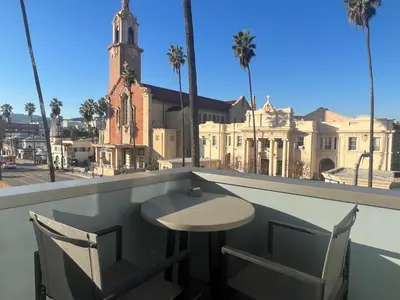 a table and chairs on a balcony with a building at Large Hollywood Corner 2 Bedroom with Private Balcony in Los Angeles