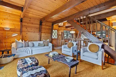 a living room with a staircase in a cabin at Pet & Kid Friendly Cozy Cabin, BBQ, Firepit, Outdoor Dining, Forest Views in Lake Arrowhead
