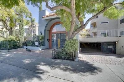 a building with a tree in front of a building at 1 Mi to the Ocean Long Beach Condo with Pool Access in Long Beach