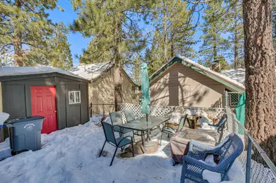 a patio with a table and chairs in the snow at Cozy Cabin with Deck - 2 Mi to Bear Mountain Resort! in Big Bear Lake