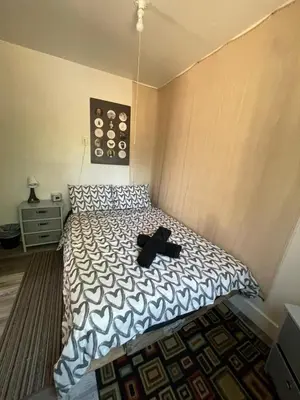 a bedroom with a bed with a black hat on it at Petite Guesthouse with Kitchenette and Private Bathroom in Lake Isabella