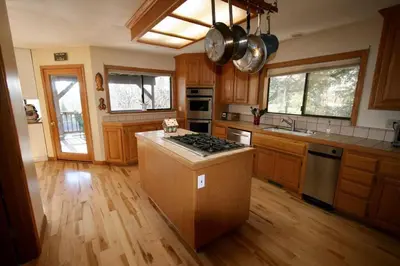 a kitchen with wooden cabinets and a stove top oven at Outrageous Lake View Villa pets ok in Lake Arrowhead