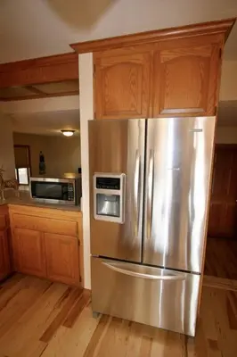 a kitchen with a stainless steel refrigerator and wooden cabinets at Outrageous Lake View Villa pets ok in Lake Arrowhead