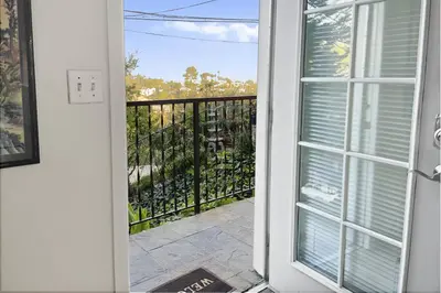 a door leading to a balcony with a view of a yard at Secret Stairs Studio #1 in Los Angeles