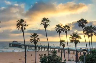 a group of palm trees on a beach with a pier at Secret Stairs Studio #1 in Los Angeles