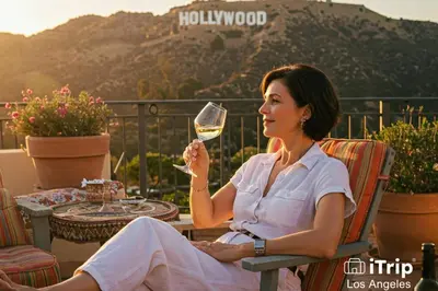 a woman sitting in a chair holding a glass of wine at Secret Stairs Studio #1 in Los Angeles
